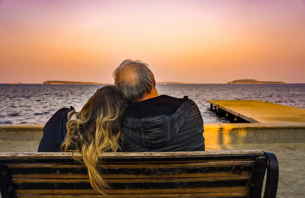 OldCoupleWatchingBeautifulSunsetOnShoreFeelingsHappyRetirement