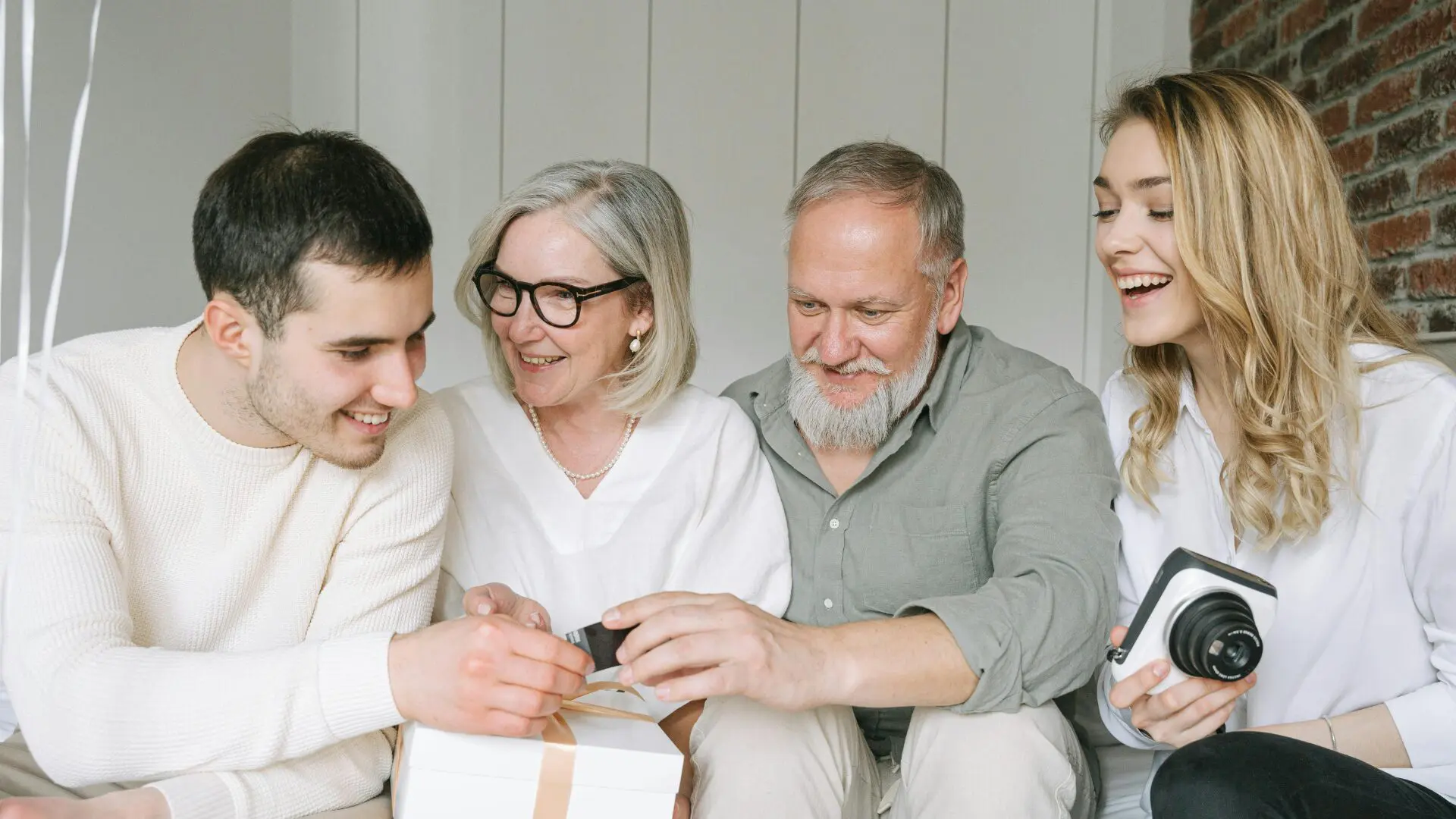 A multi-generational family happily opening a gift together, representing the joy of moving closer to loved ones.